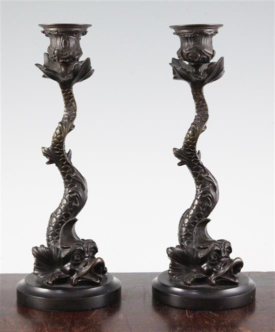 A pair of 19th century bronze candlesticks, modelled as dolphins, 10.5in.